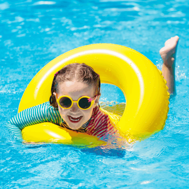 1BlogPediatric Young girl laughing in a pool with a yellow float ring during summer break in Olathe, KS