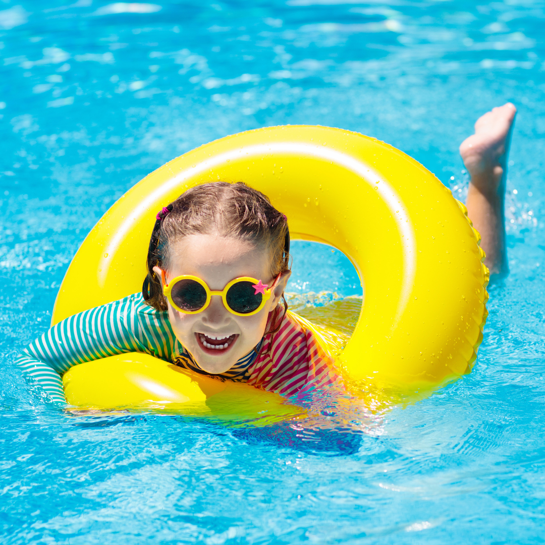1BlogPediatric Young girl laughing in a pool with a yellow float ring during summer break in Olathe, KS